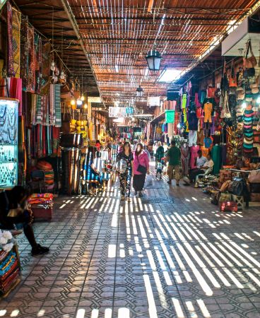 Pasillo del zoco de Fez con luz filtrada y puestos de artesanía, Marruecos
